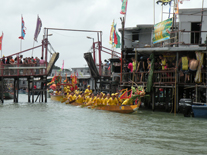 A dragon boat of Hap Sim Tong passes under the Sun Ki Bridge with a deity boat in tow